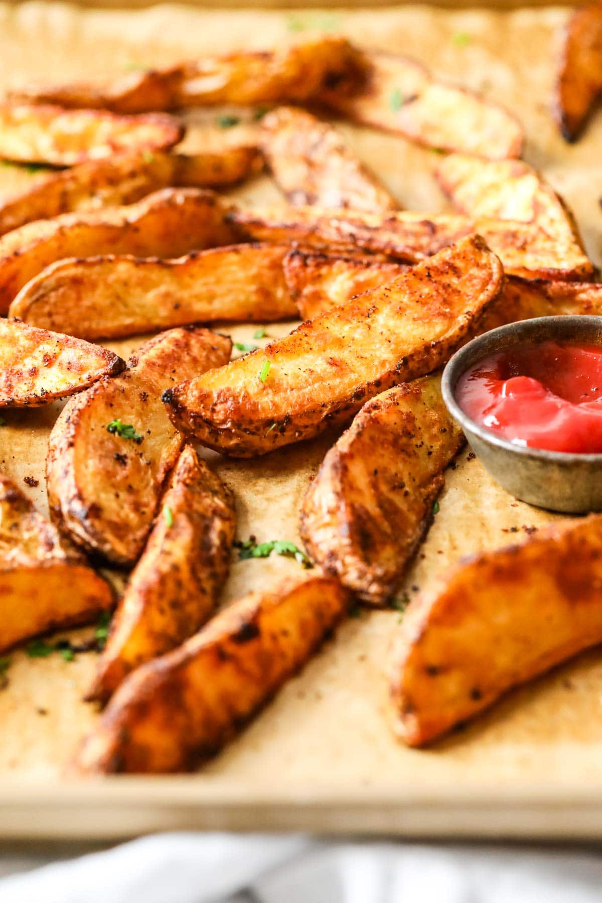 Close-up view of potato wedges on a baking tray.