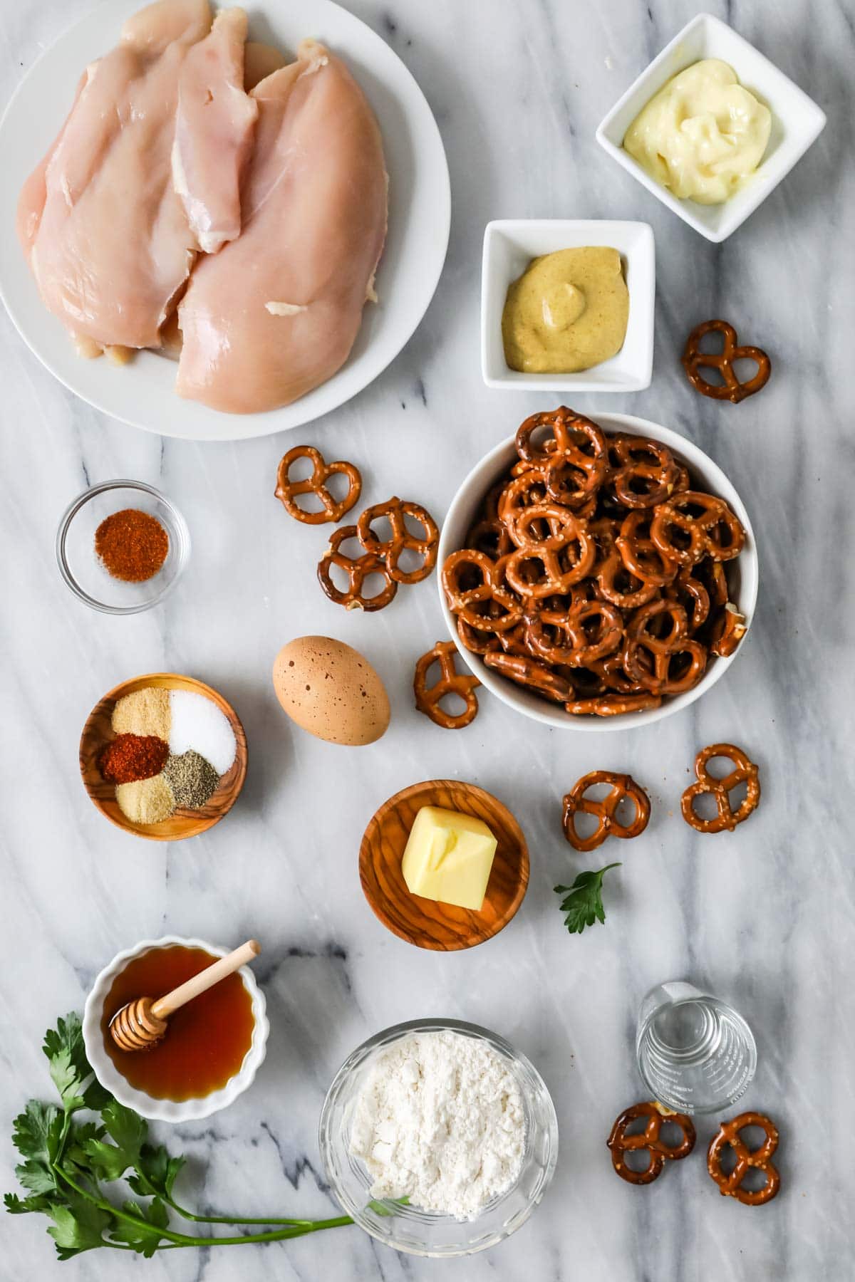 Overhead view of ingredients including chicken breasts, pretzels, mustard, and more.