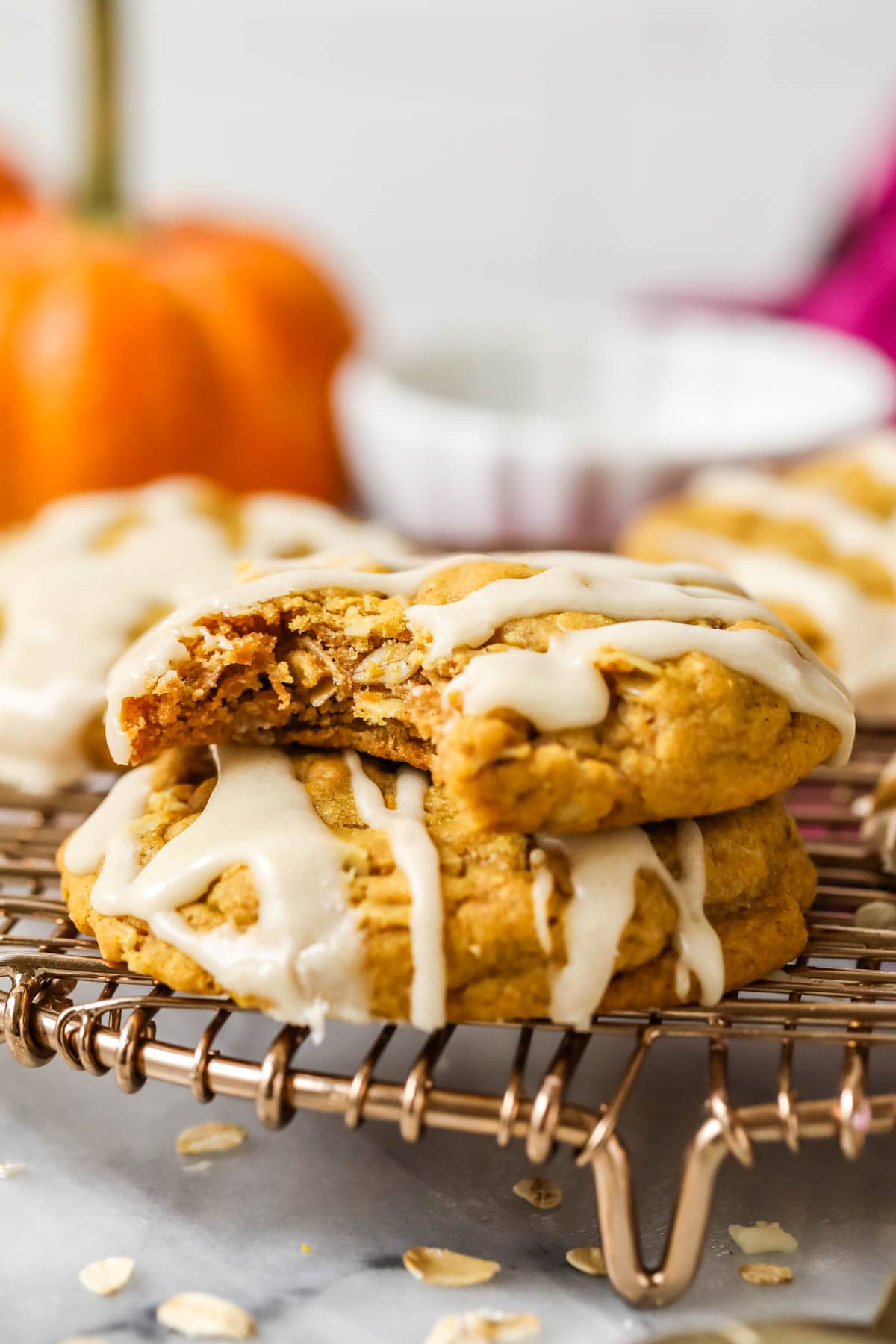 Stack of two pumpkin oatmeal cookies with the top cookie missing a bite.