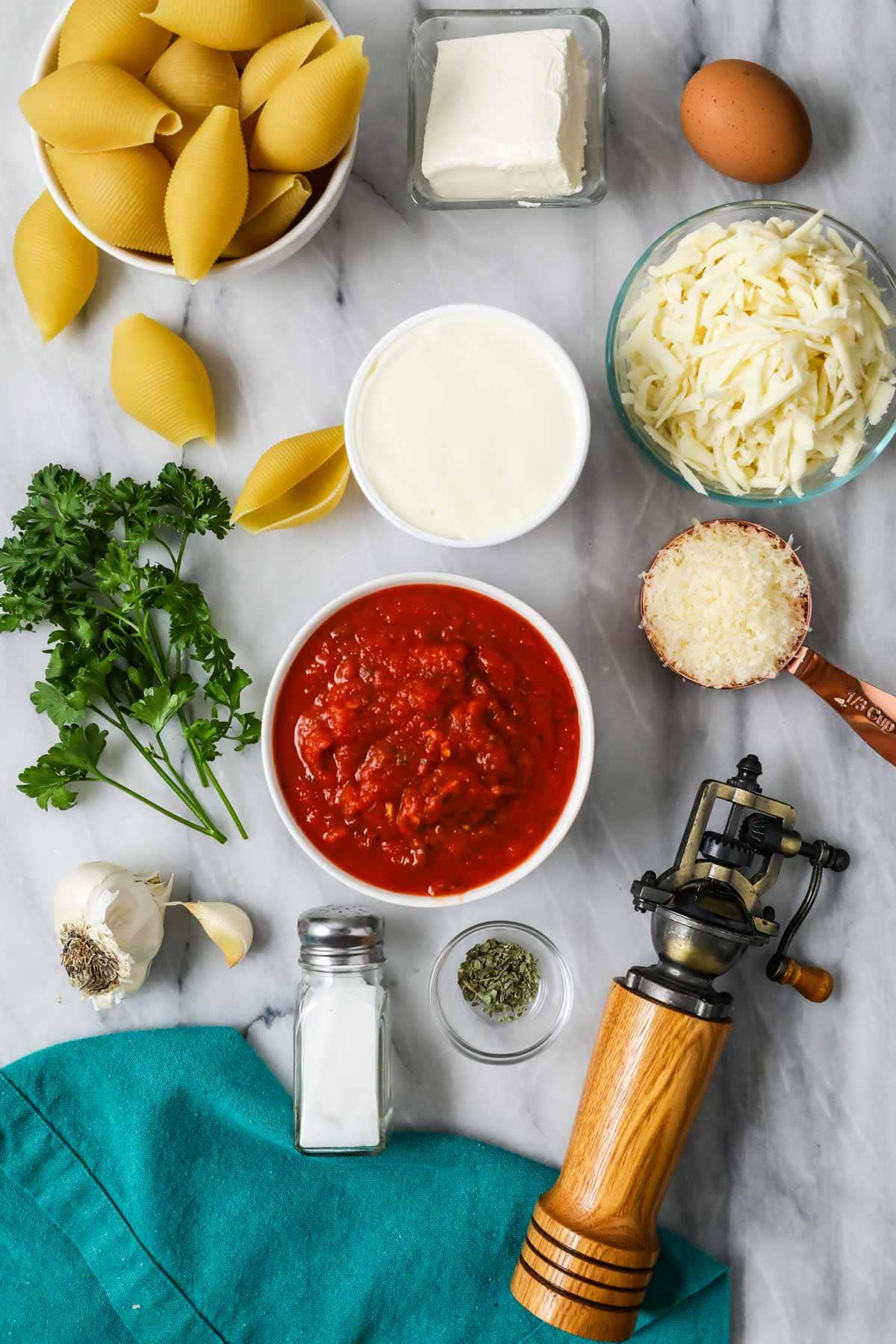 Overhead view of ingredients including jumbo pasta shells, marinara sauce, cheese, and more.