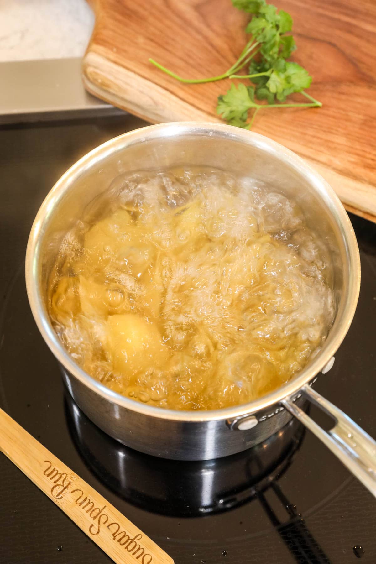 Overhead view of a pot of jumbo pasta shells boiling on the stovetop.