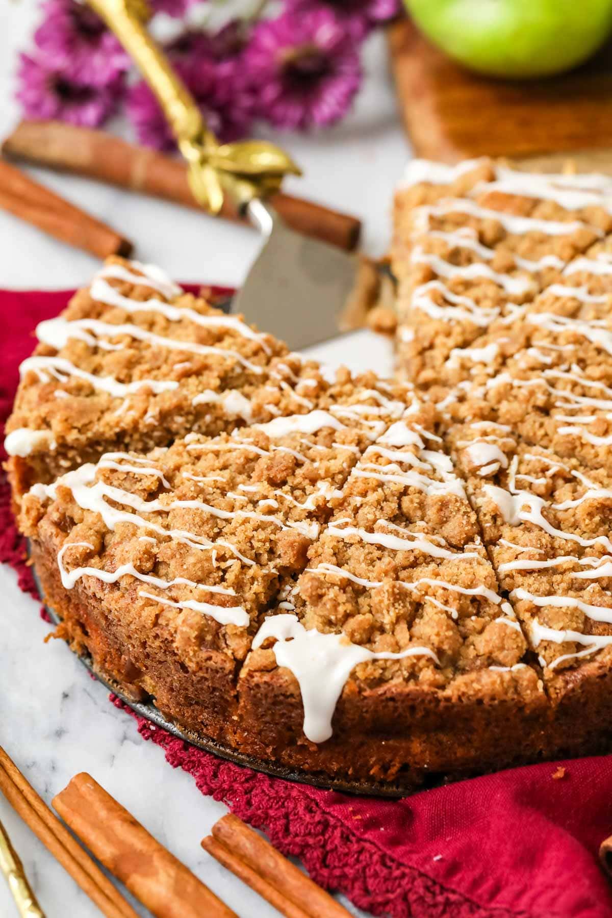 Apple crumb cake cut into slices and drizzled with vanilla glaze