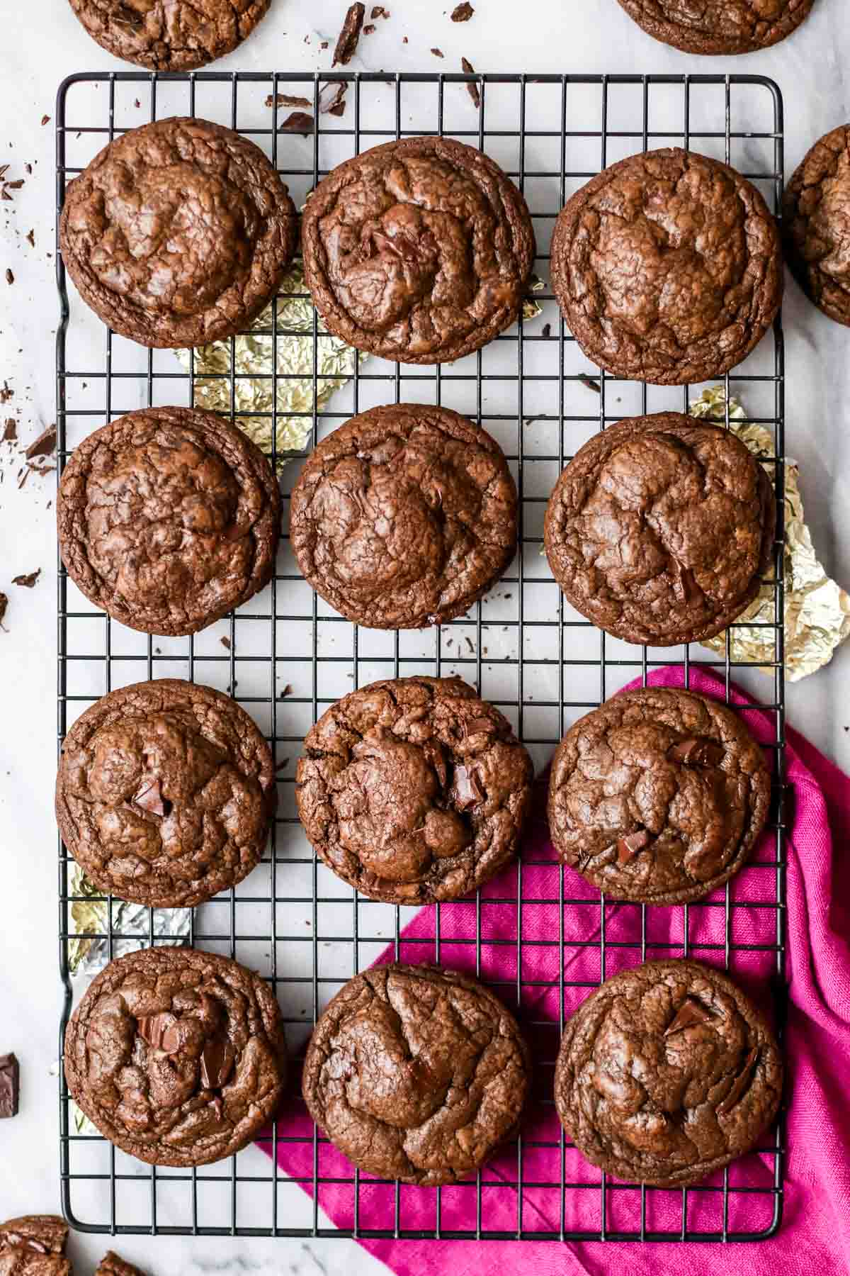 Overhead view of neat rows of chocolate cookies on a cooling rack.