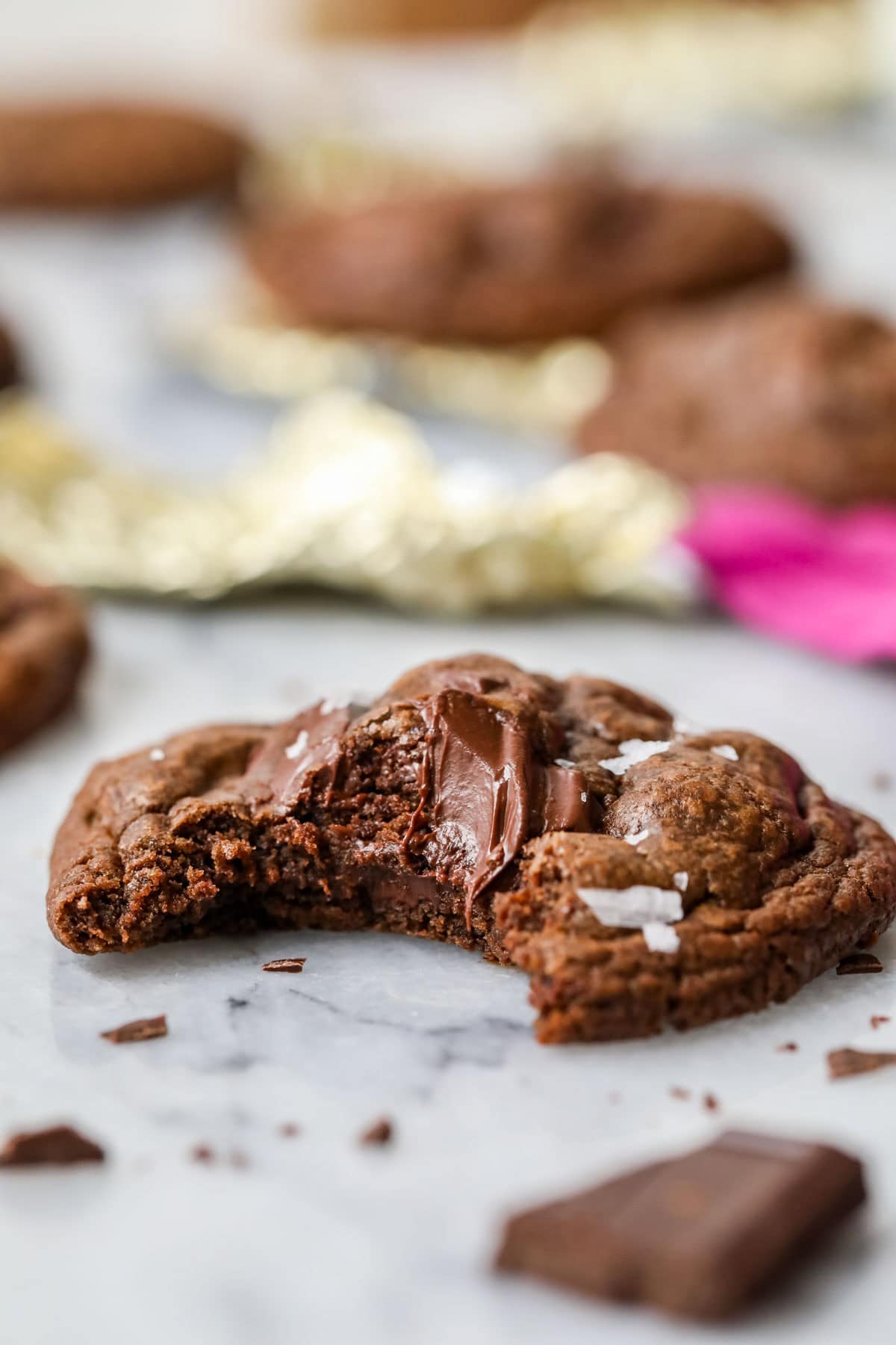 Close-up view of a bite missing from a cookie made with cocoa powder and chocolate chunks.