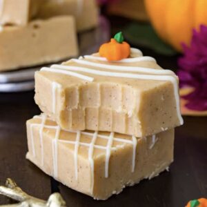 Stack of two pieces of pumpkin fudge with the top piece missing a bite.