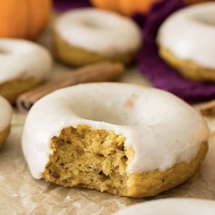 Close-up view of a pumpkin donut with a bite missing.