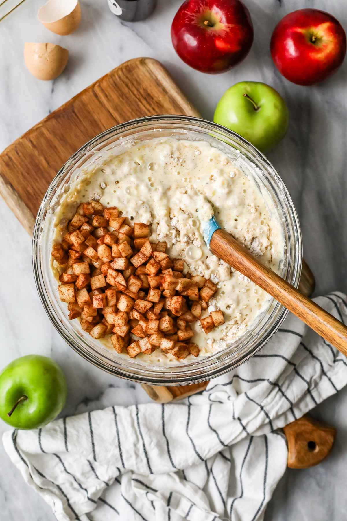 pancake batter in a bowl with cinnamon sugar apples