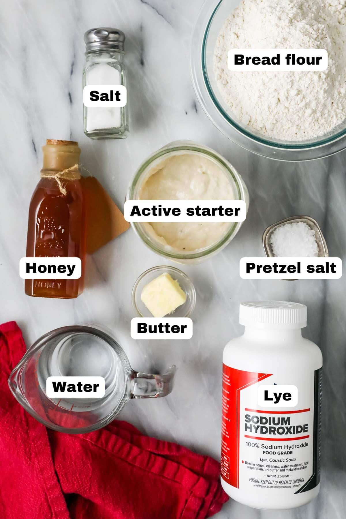 Overhead view of labeled ingredients including sourdough starter, honey, lye, and more.