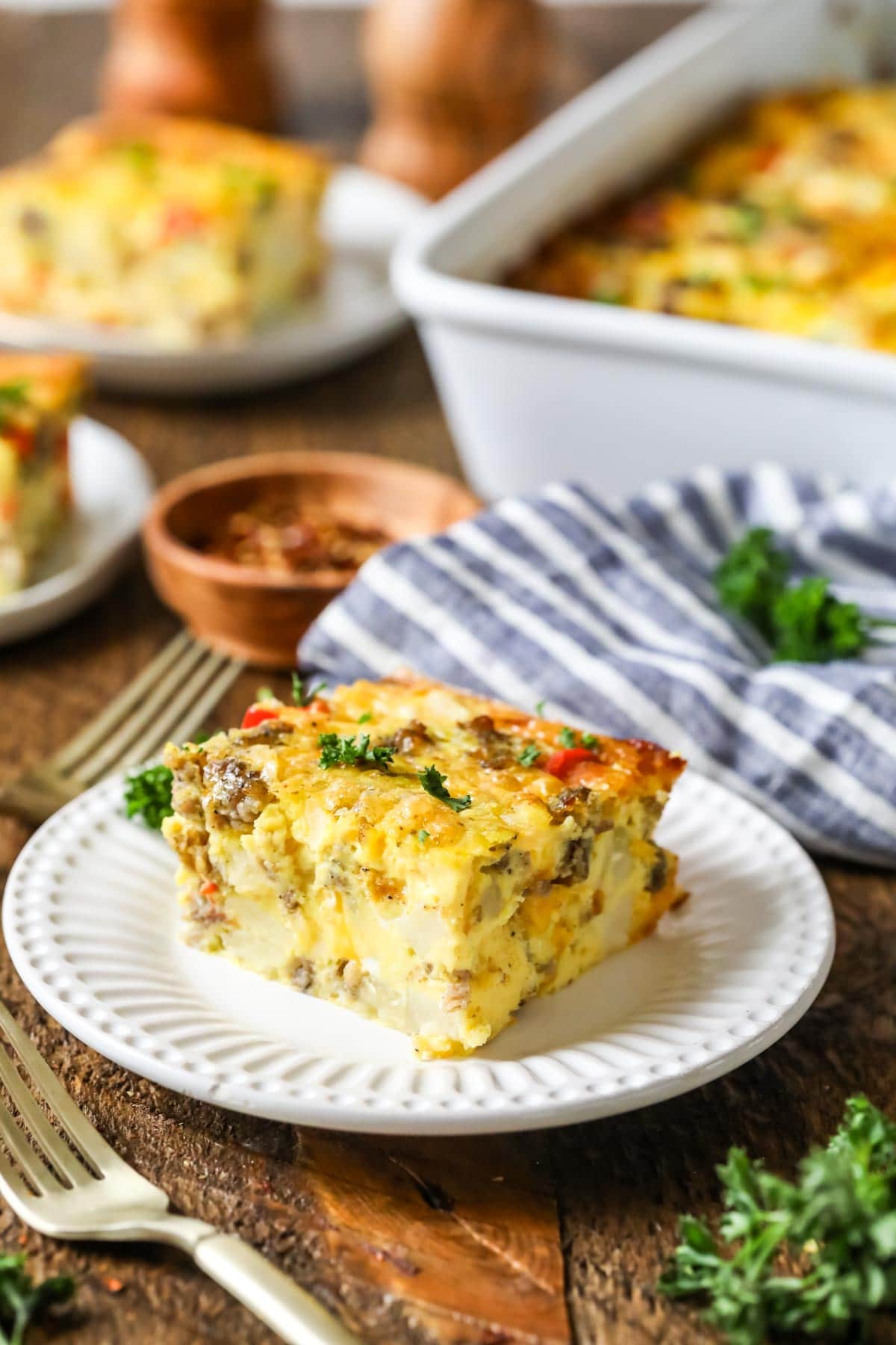 Slice of breakfast casserole made with sausage, peppers, and hash browns on a plate.