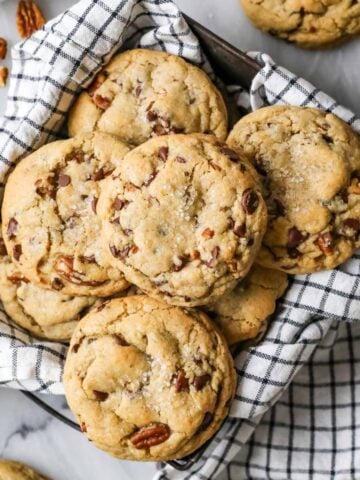 Overhead view of chocolate chip banana bread cookies in a tea towel lined dish.