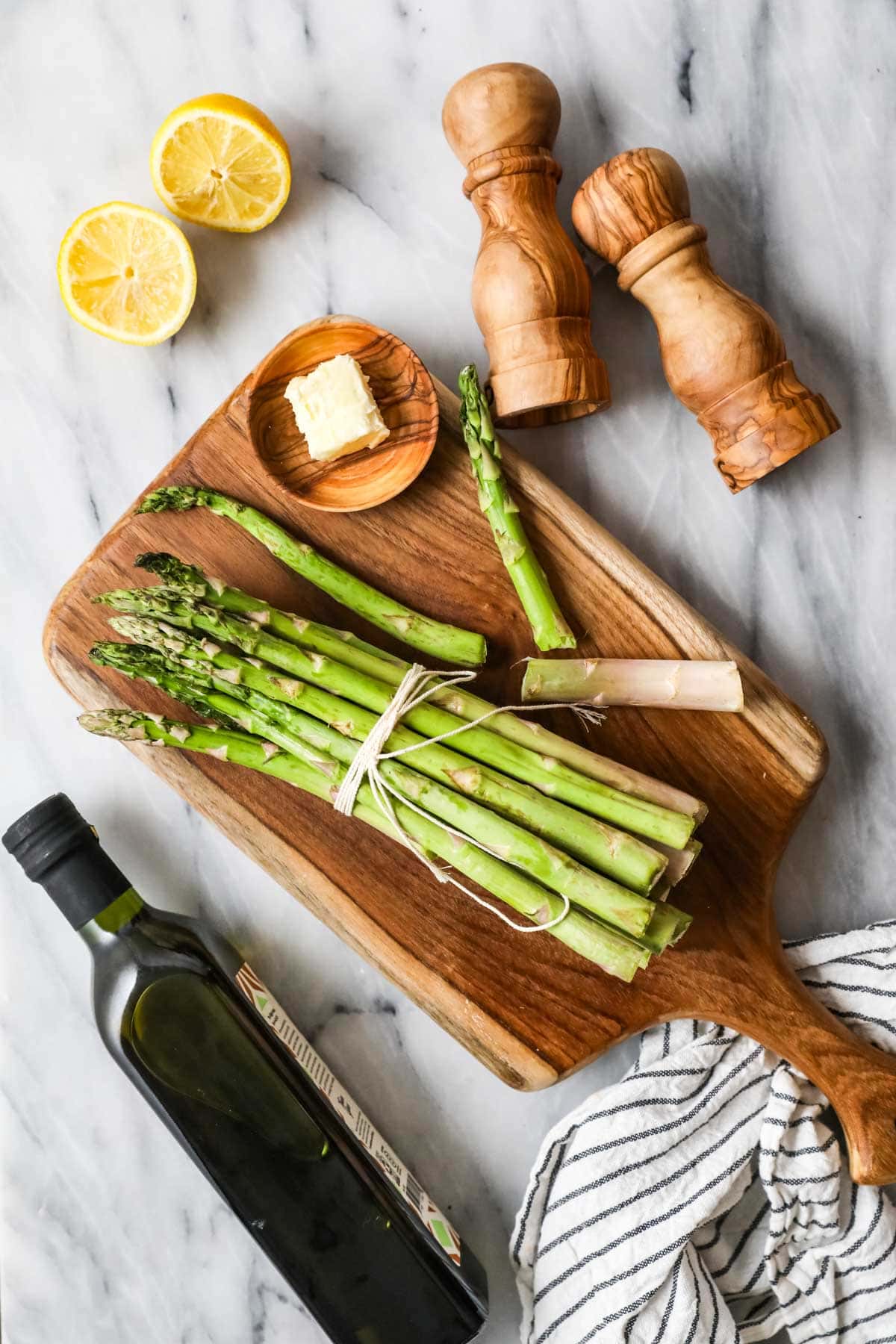 Overhead view of ingredients including asparagus, butter, lemon, and olive oil.