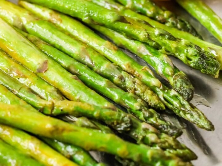 Asparagus spears in a saucepan after being sautéed with lemon and butter.