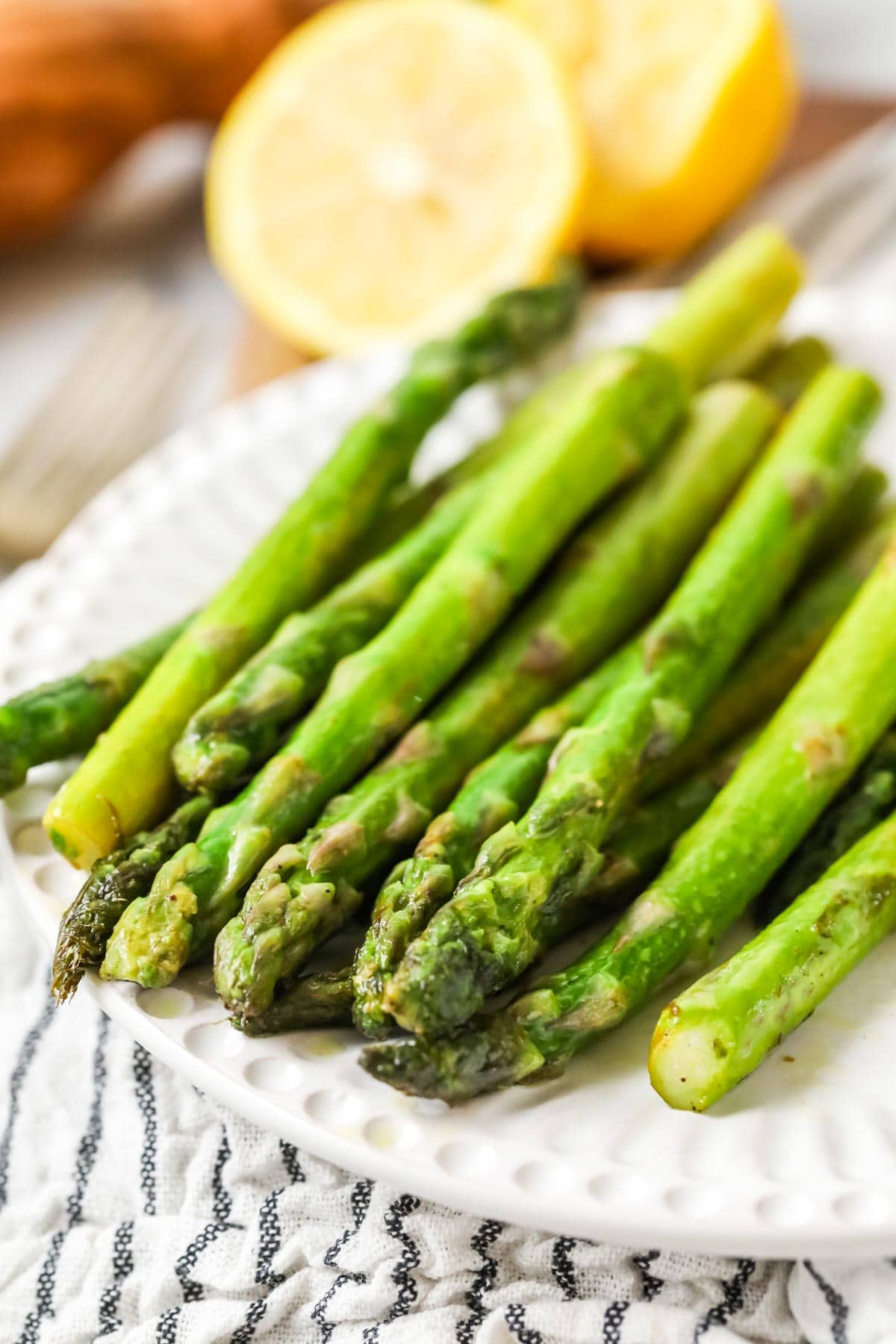 Close view of sautéed asparagus on a plate.