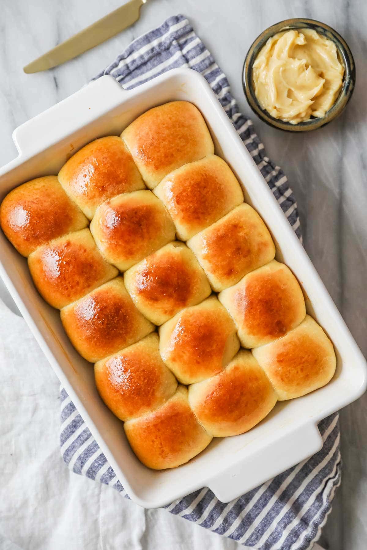 Overhead view of a baking dish of dinner rolls made with sourdough starter.