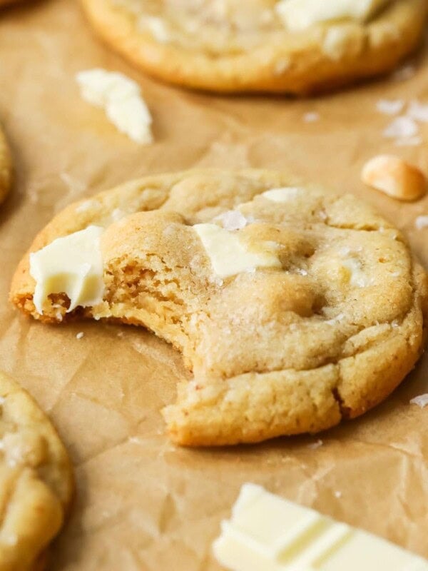 Close-up view of a white chocolate macadamia nut cookie missing a bite.