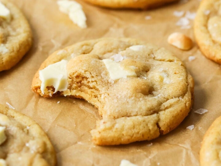 Close-up view of a white chocolate macadamia nut cookie missing a bite.