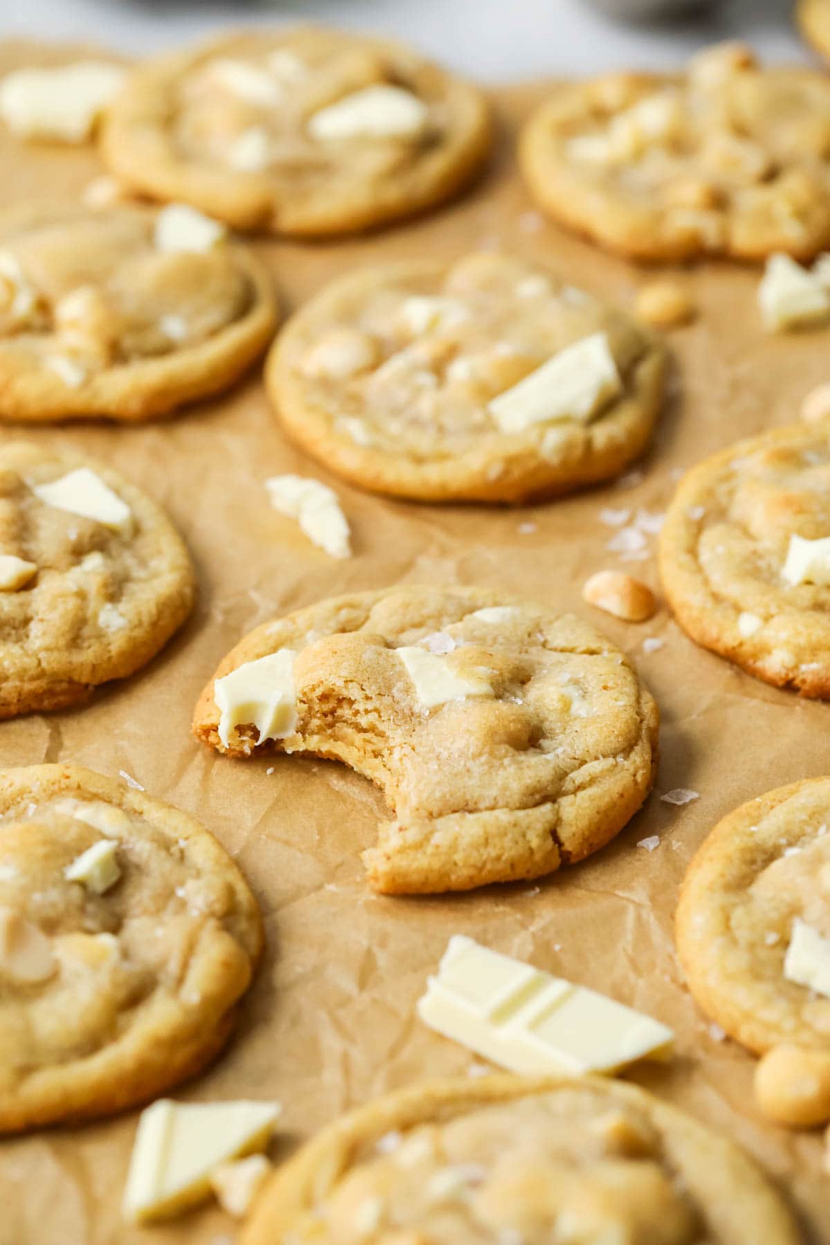 Close-up view of a white chocolate macadamia nut cookie missing a bite.