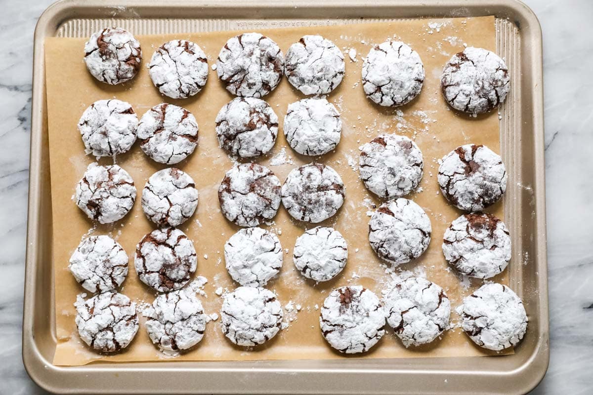 Overhead view of chocolate crinkle cookies on a baking sheet.