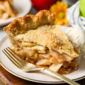 Slice of pie made from an easy apple pie recipe on a plate with a fork beside it.