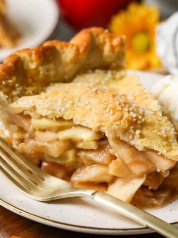 Slice of pie made from an easy apple pie recipe on a plate with a fork beside it.