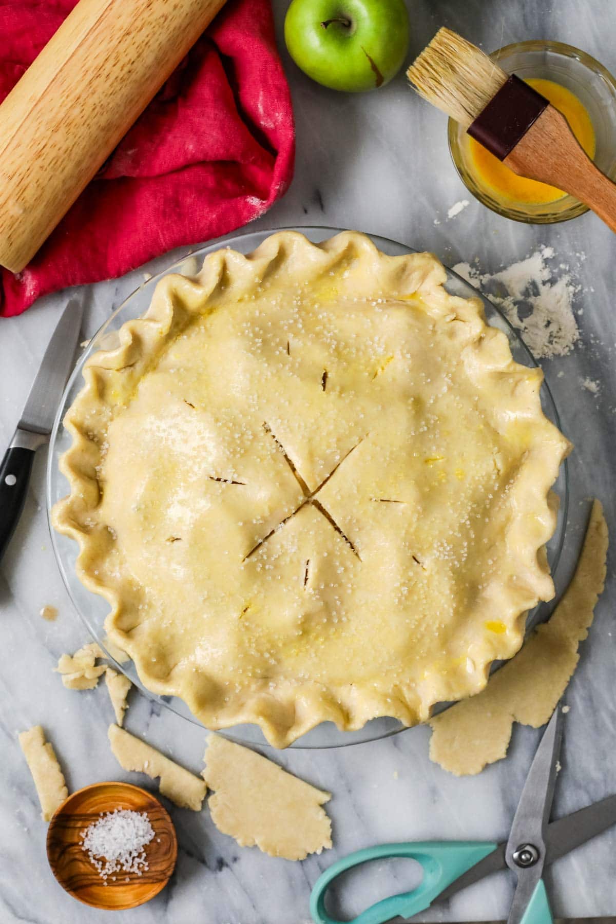 Overhead view of an unbaked pie that has been fluted and vented.