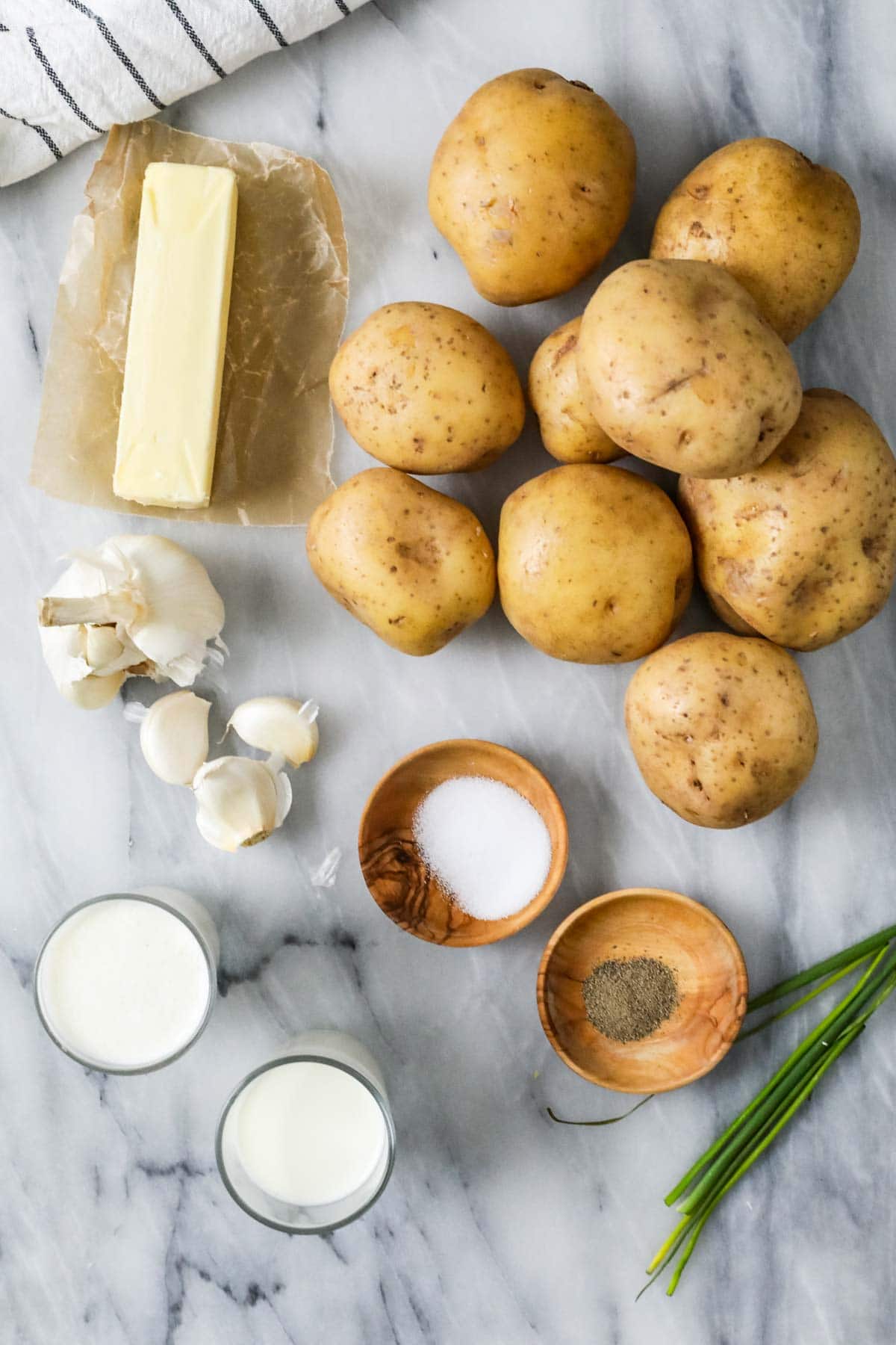 Overhead view of ingredients including potatoes, garlic, butter, and more.