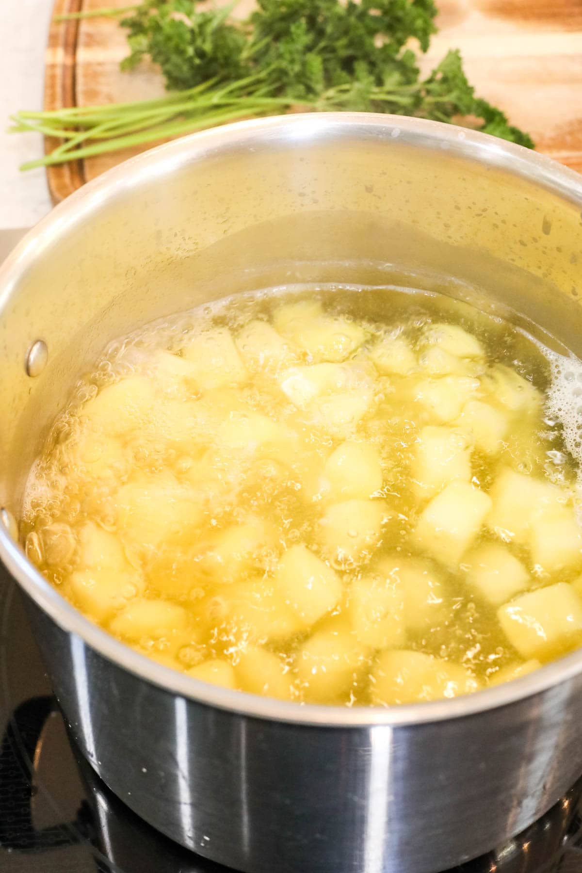 Pot of chopped potatoes boiling in water.