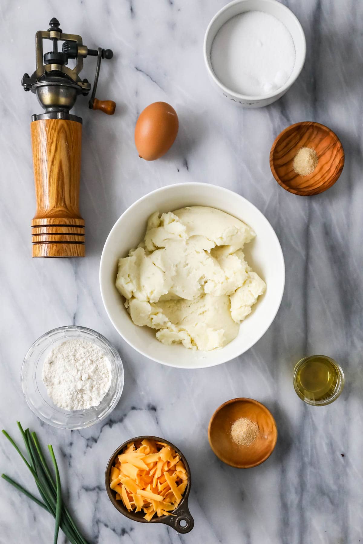 Overhead view of ingredients including mashed potatoes, cheese, egg, and more.