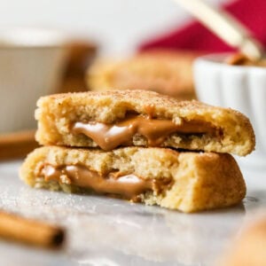 Two halves of cookie butter snickerdoodles stacked on top of each other with cookie butter spilling out of the centers.