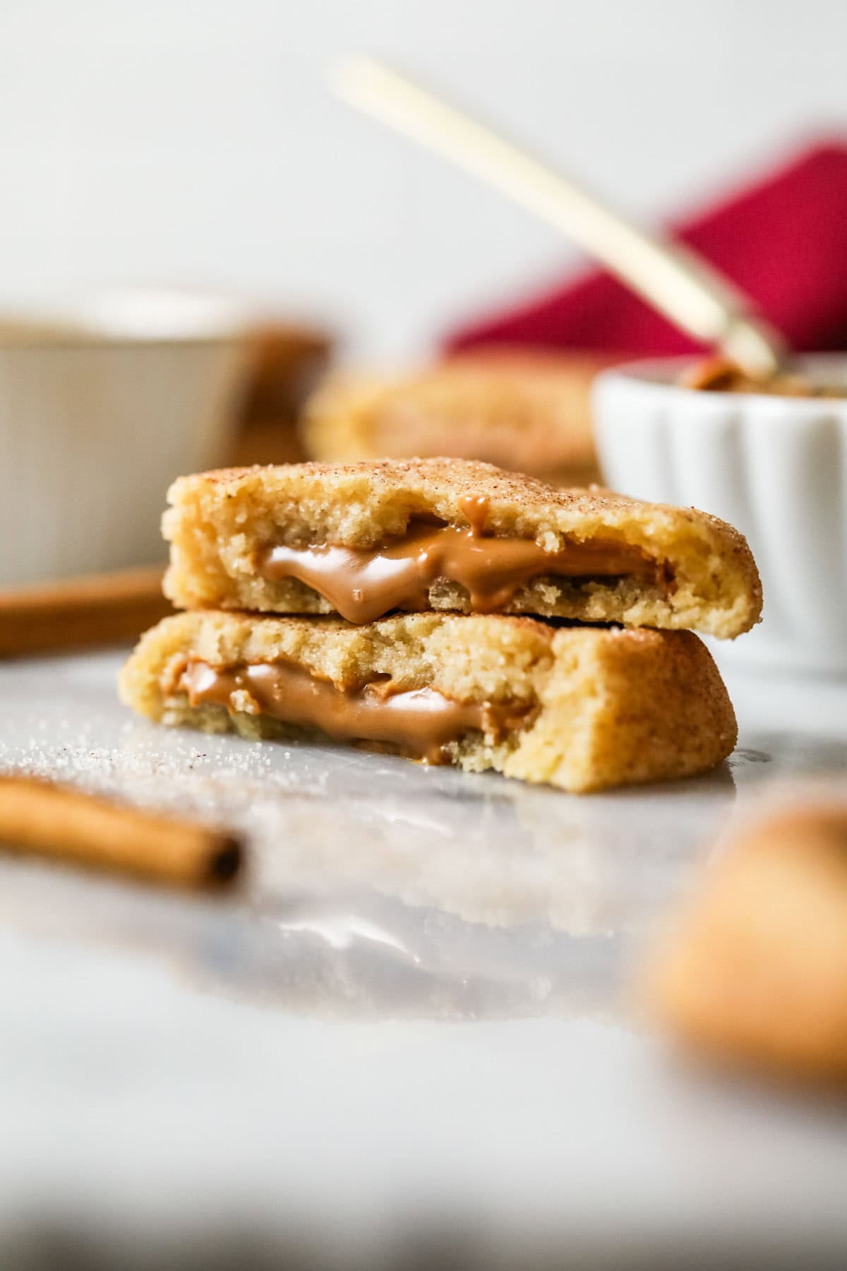 Two halves of cookie butter snickerdoodles stacked on top of each other with cookie butter spilling out of the centers.