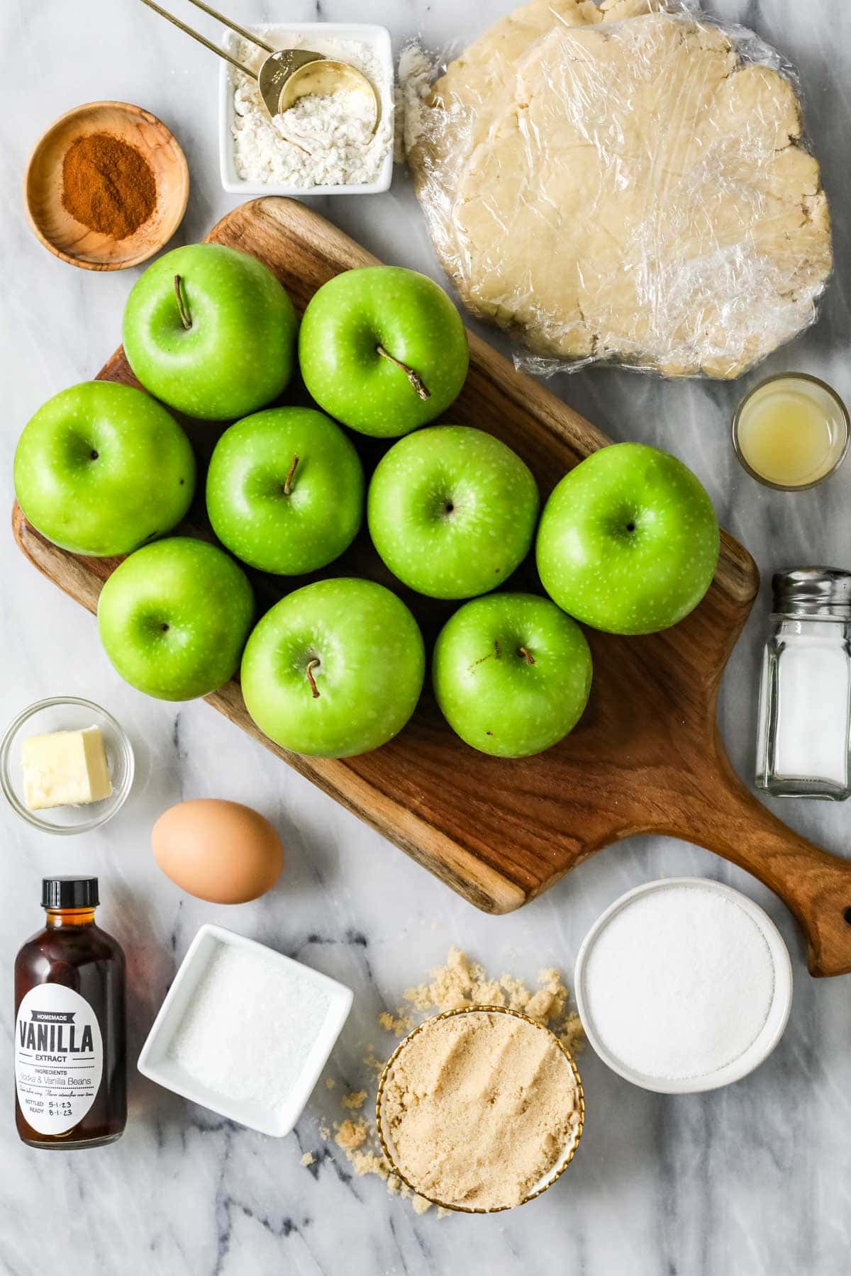 Overhead view of ingredients including apples, cinnamon, pie dough and more.