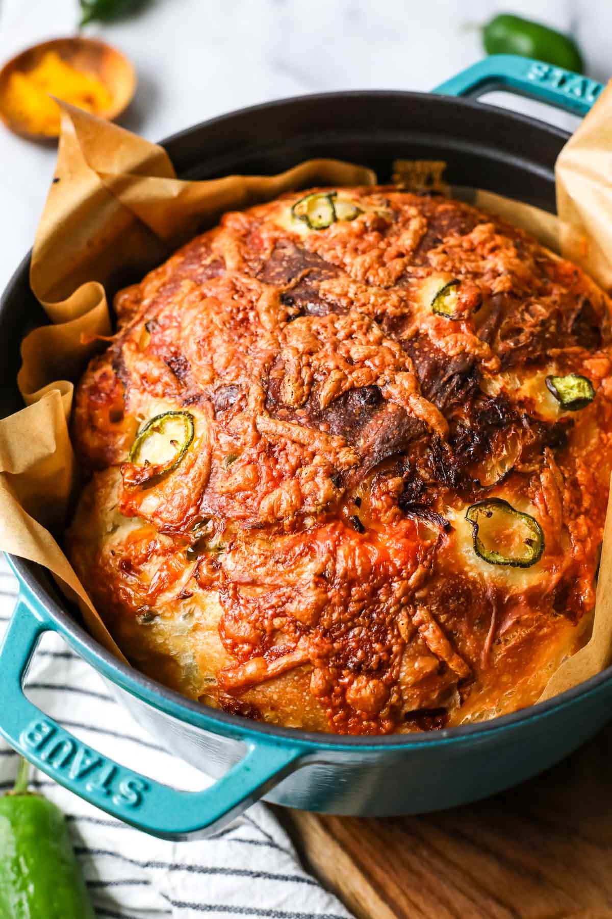 Loaf of cheddar jalapeno sourdough bread in a dutch oven.