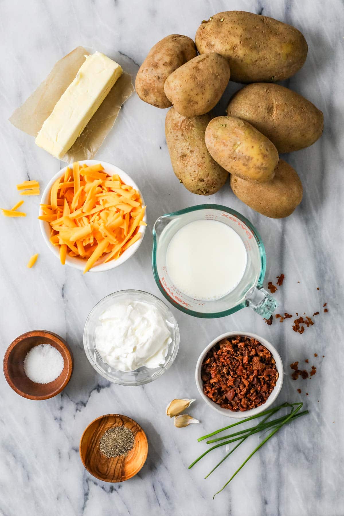 Overhead view of ingredients including potatoes, cheese, bacon, and more.