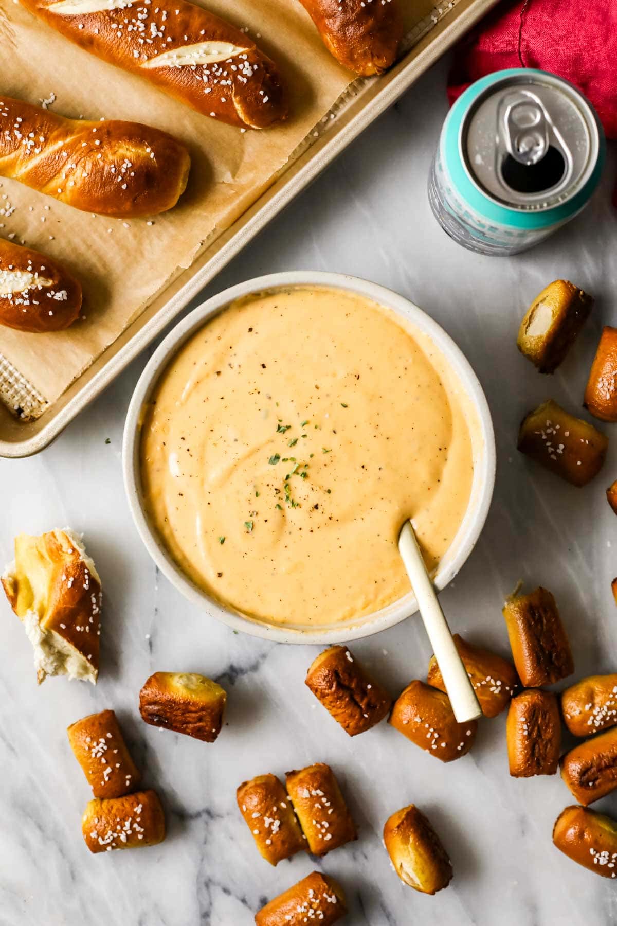 Overhead view of a cheese dip made with beer surrounded by soft pretzel pieces.