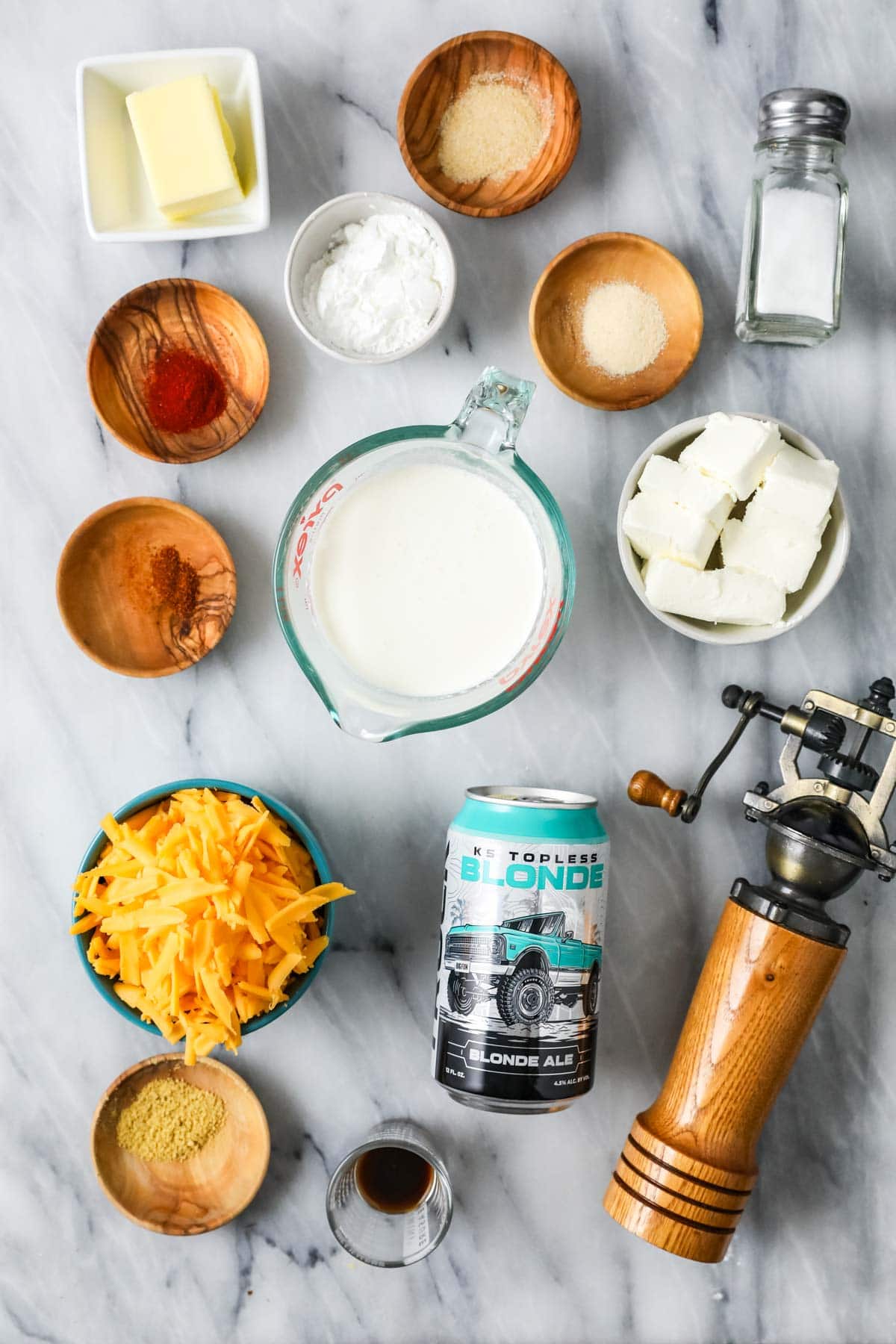 Overhead view of ingredients including beer, cheese, spices, and more.