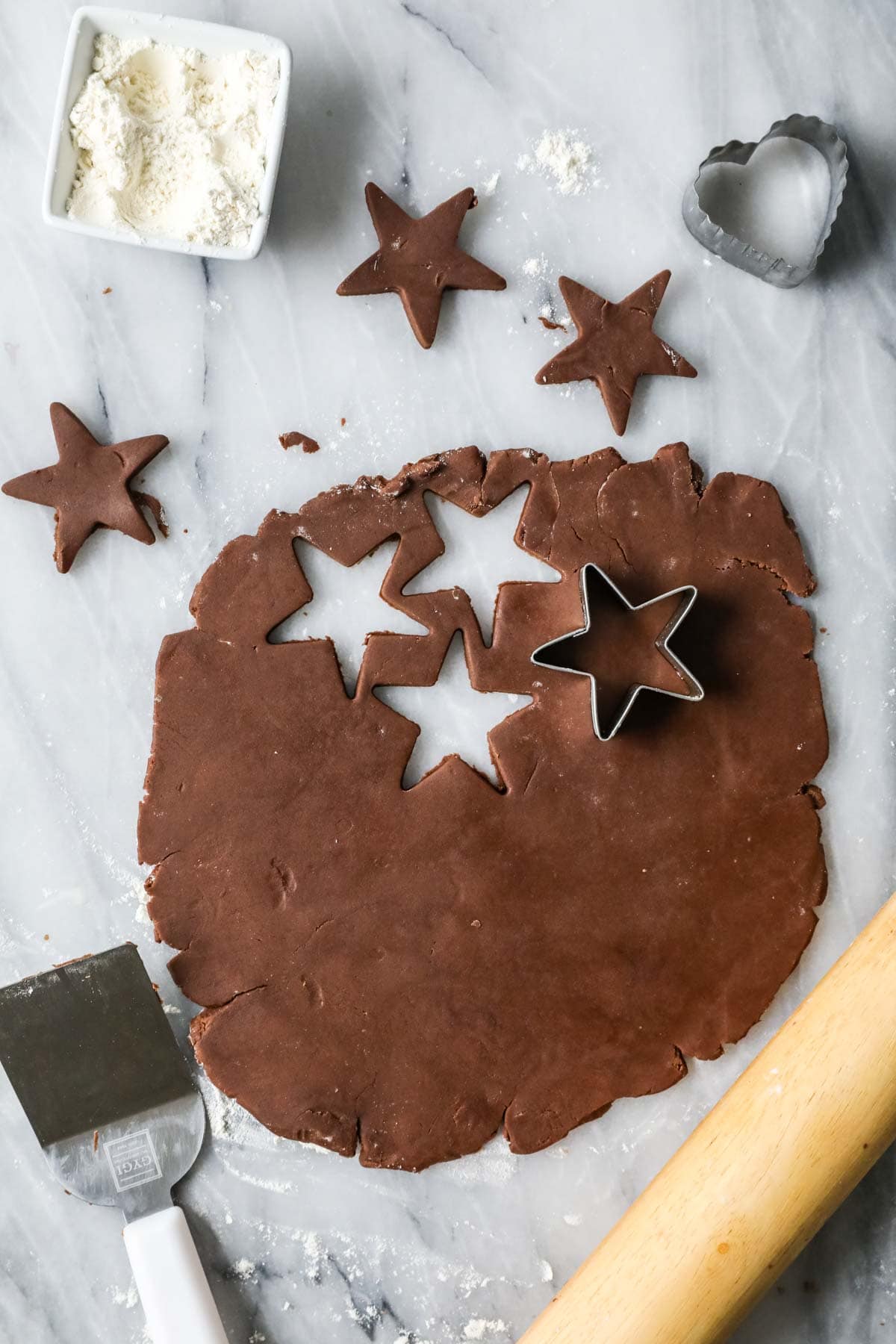 Star shapes being cut our of a chocolate shortbread dough.