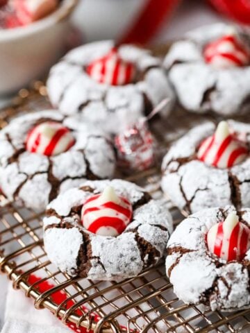 Christmas kiss cookies made with candy cane kisses on a cooling rack.