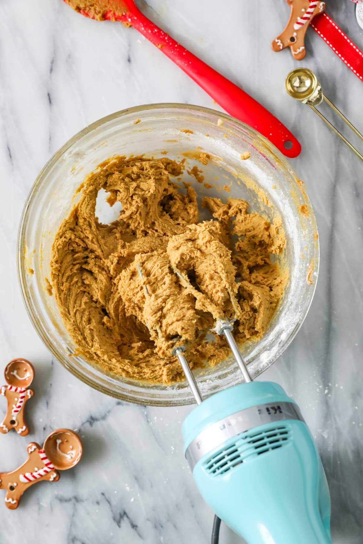 Overhead view of a gingerbread cookie dough after being mixed with an electric mixer.