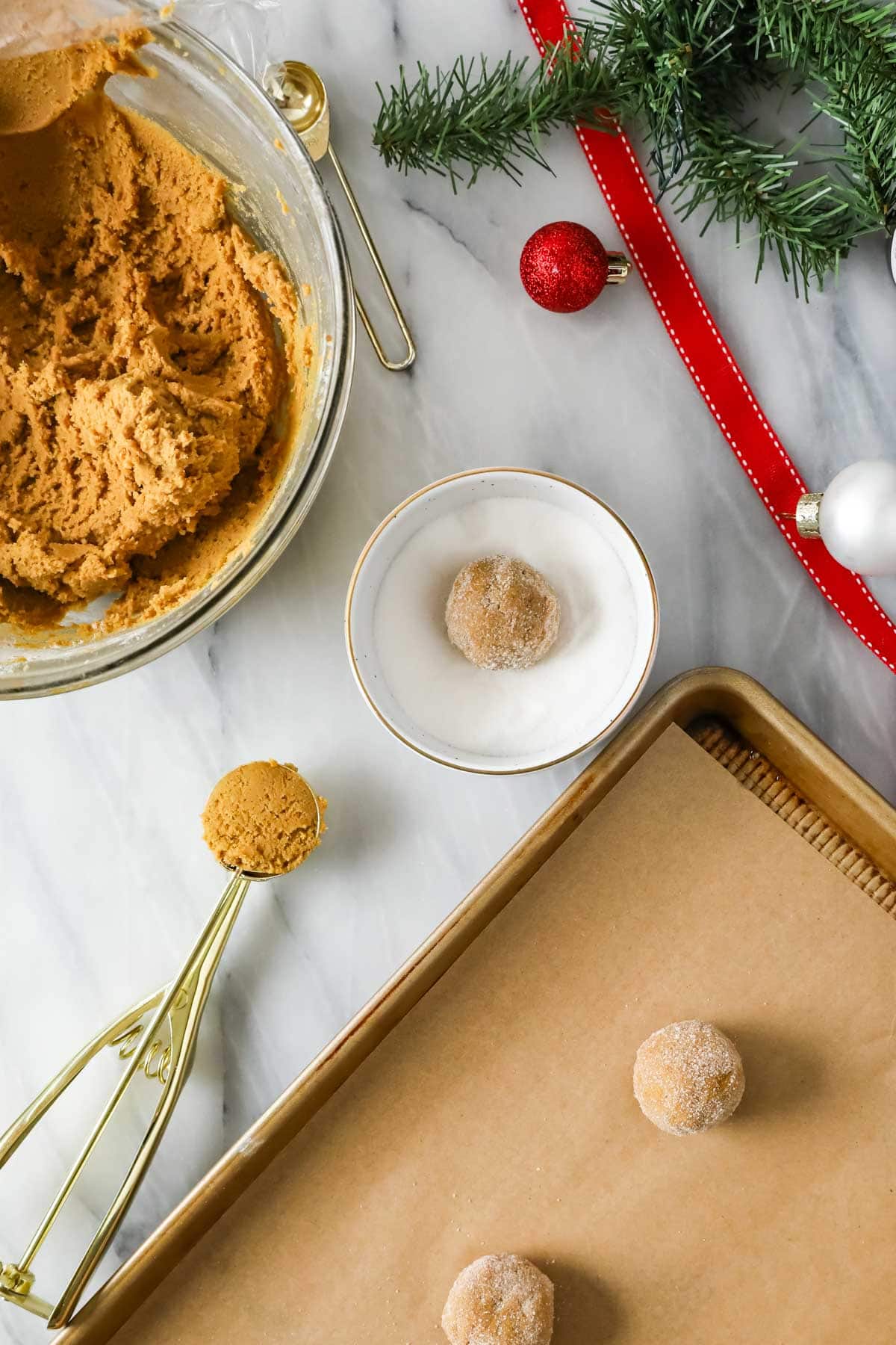 Gingerbread cookie dough balls that have been scooped and rolled through granulated sugar.