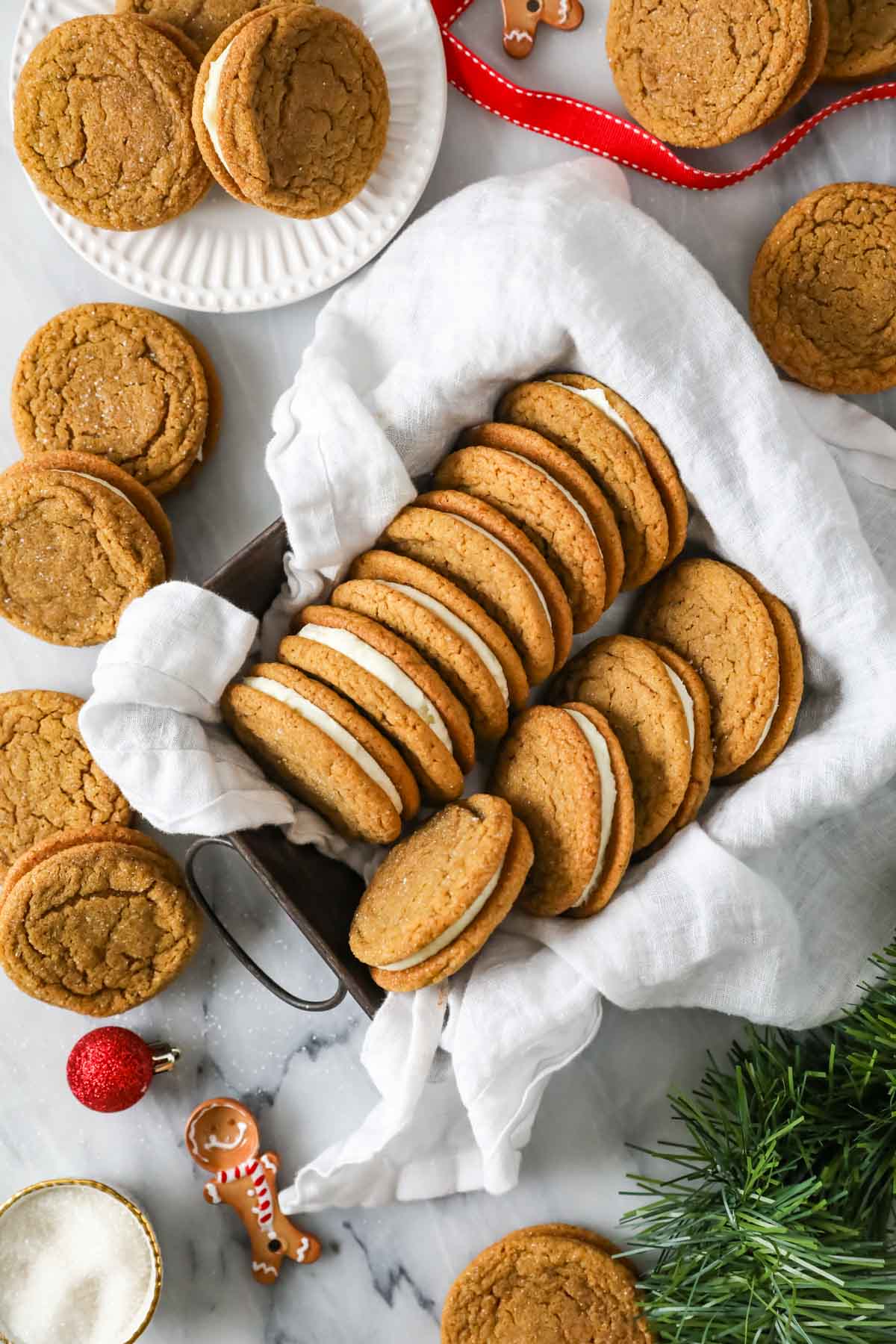 Overhead view of gingerbread sandwich cookies arranged in a metal pan.