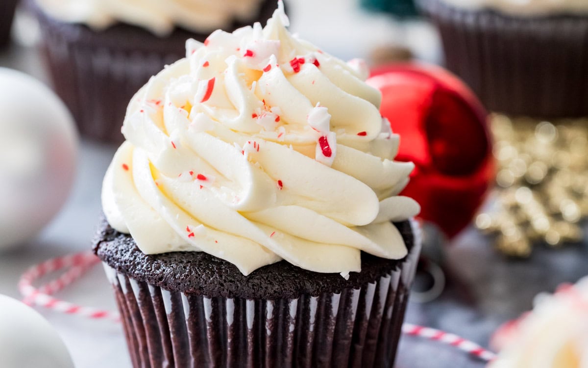 Dark chocolate cupcake topped with white chocolate peppermint buttercream and crushed candy cane pieces to mimic peppermint bark.