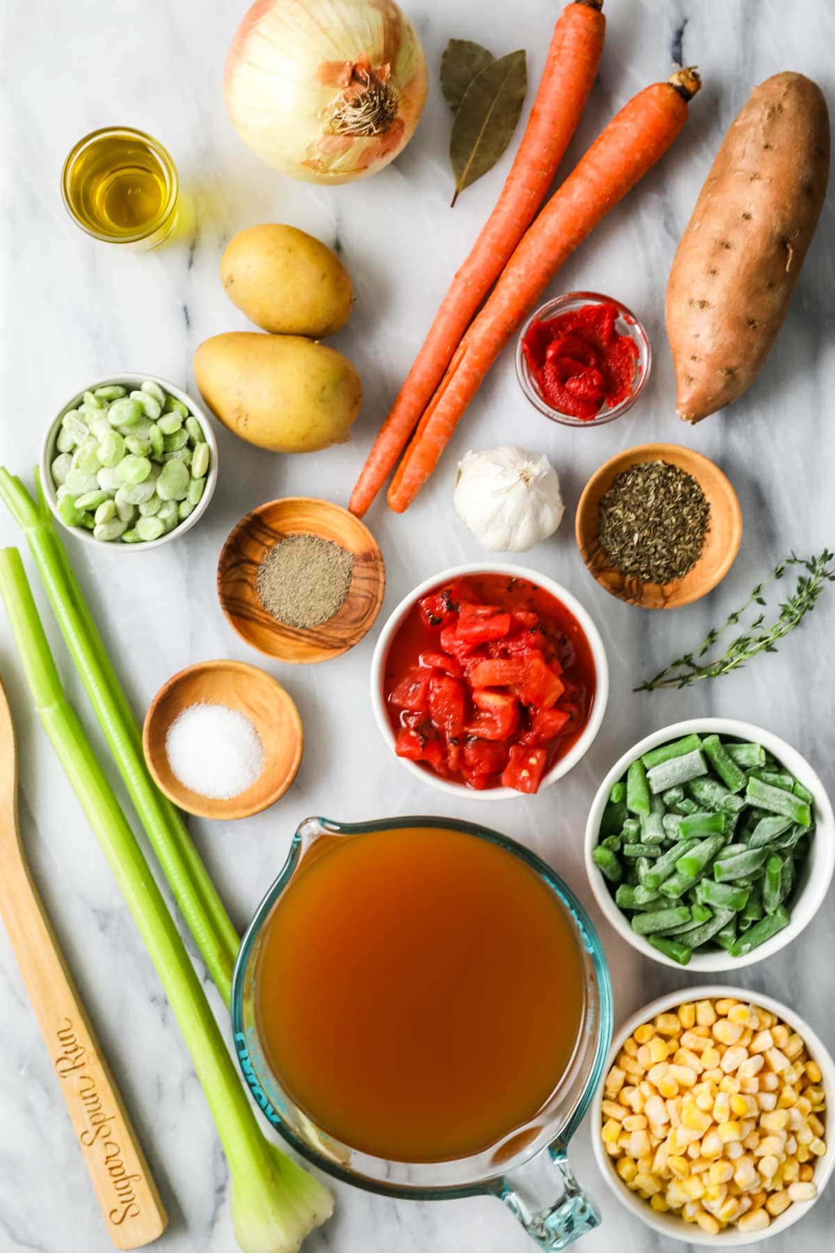 Overhead view of ingredients including vegetables broth, and spices.