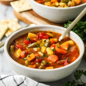 Bowl of vegetable soup made with carrots, potatoes, and more.