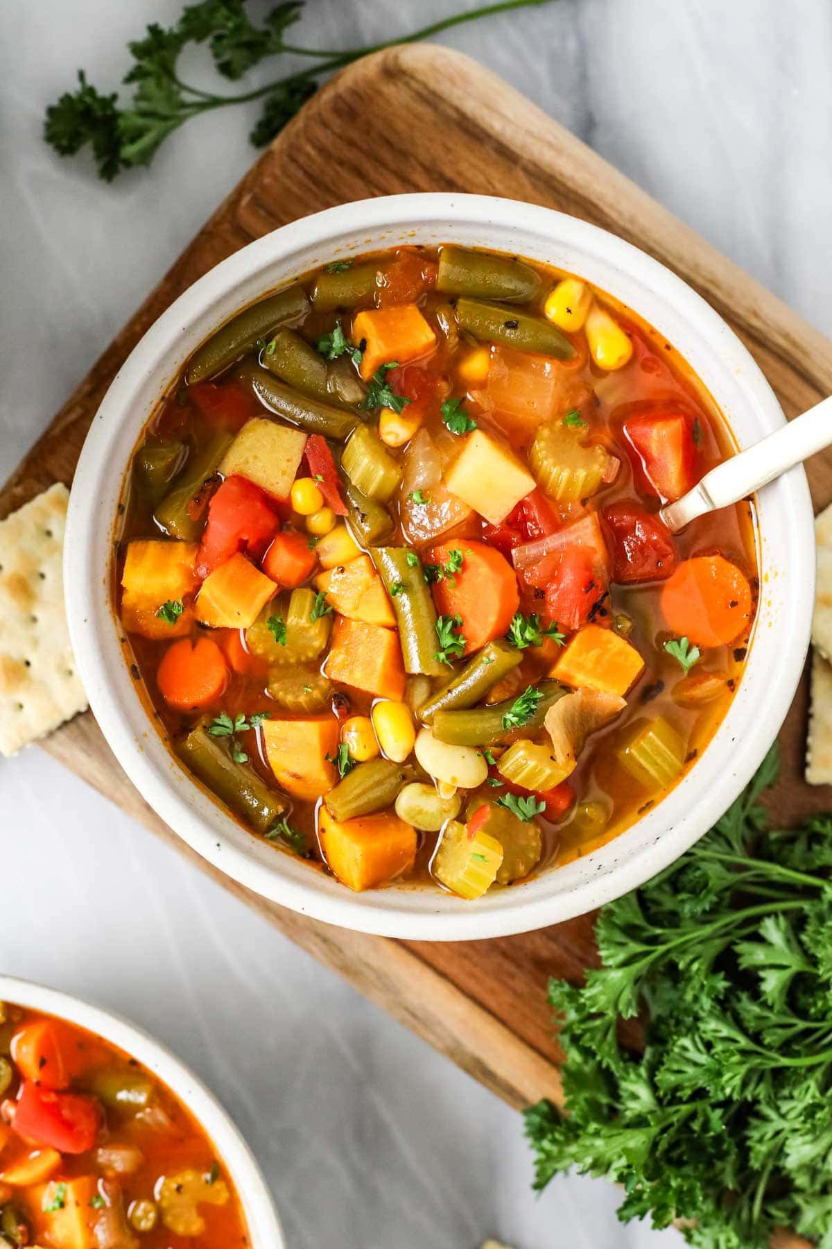 Overhead view of a bowl of vegetable soup made with carrots, potatoes, and more.