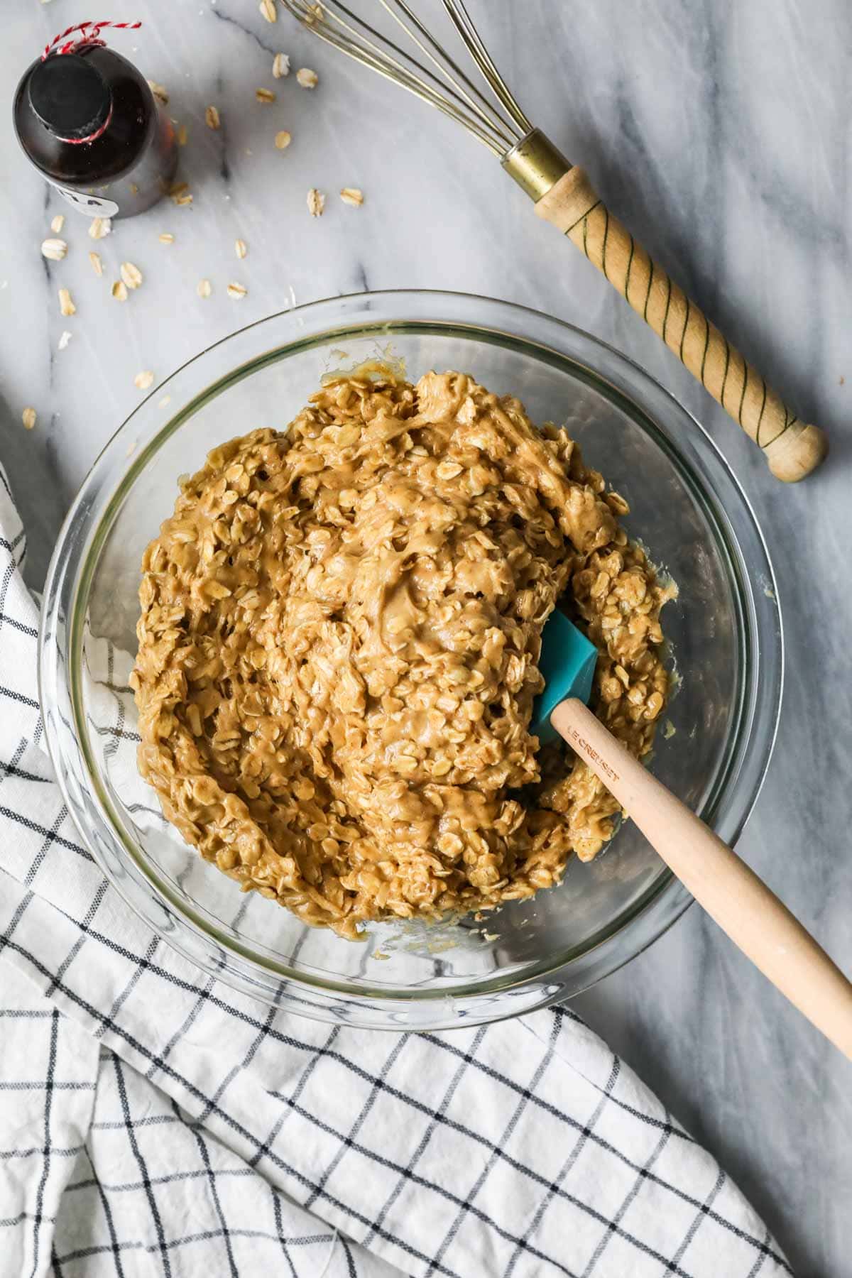 Overhead view of an oatmeal cookie dough made with sourdough discard in a clear glass bowl.