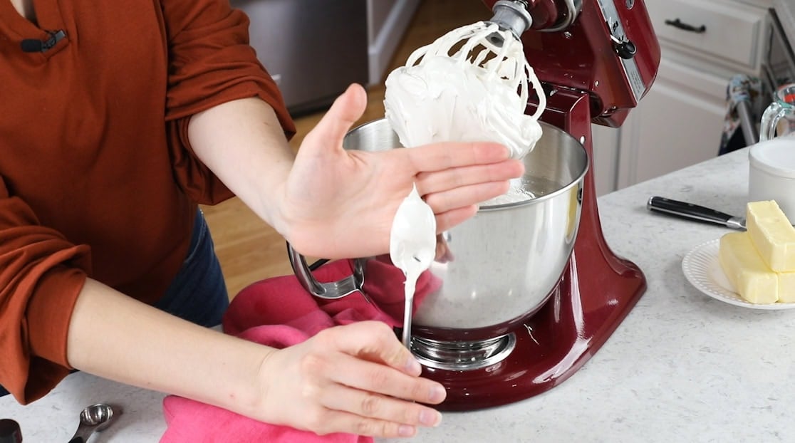 Spoon dipped in meringue to show stiff peaks.