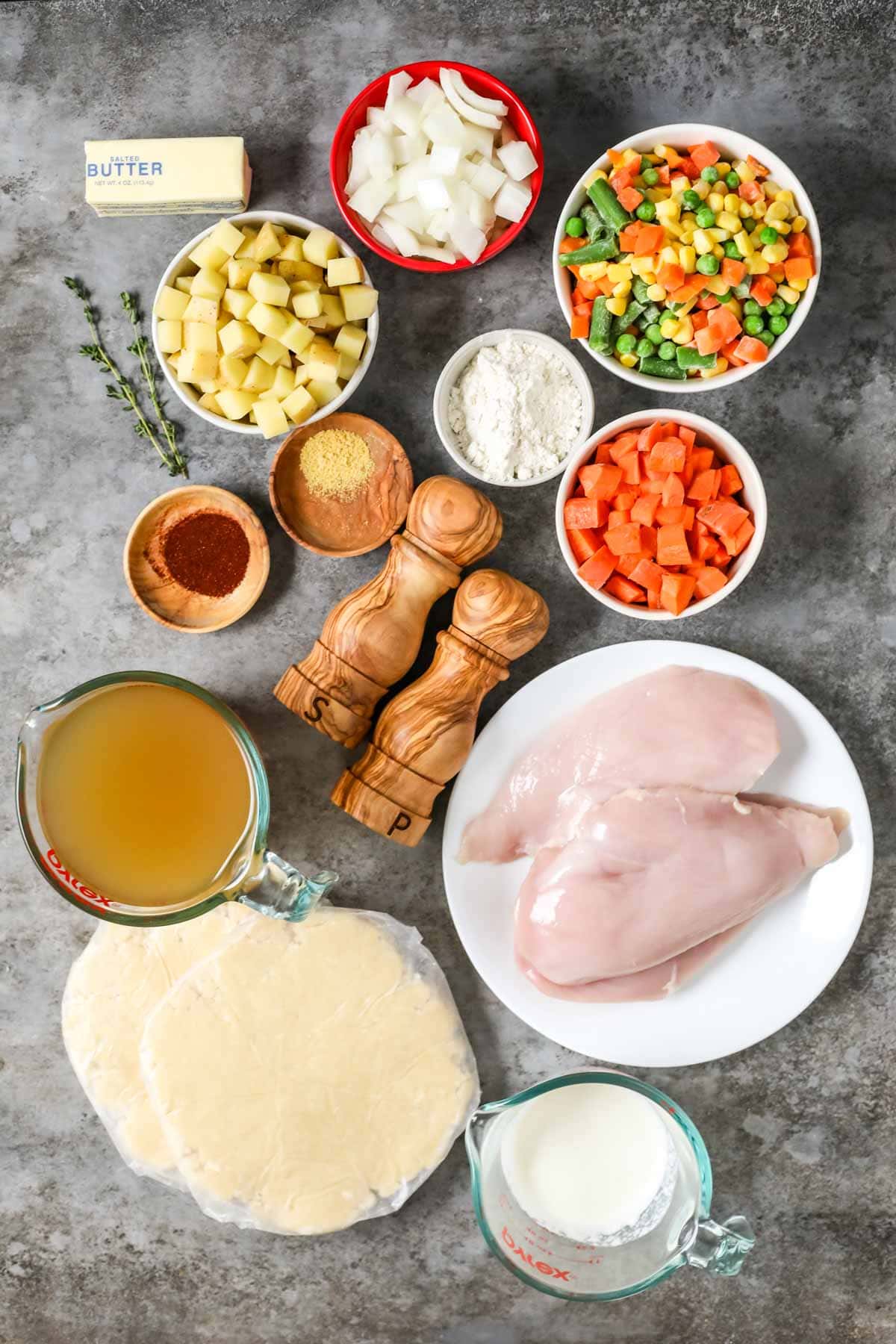 Overhead view of ingredients including chicken, frozen veggies, potatoes, and more.