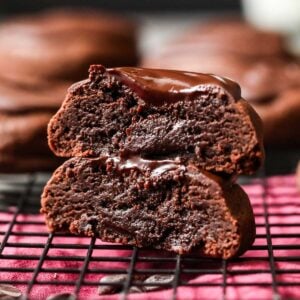 Two halves of a devil's food cookie stacked on top of each other to show a frosting center.