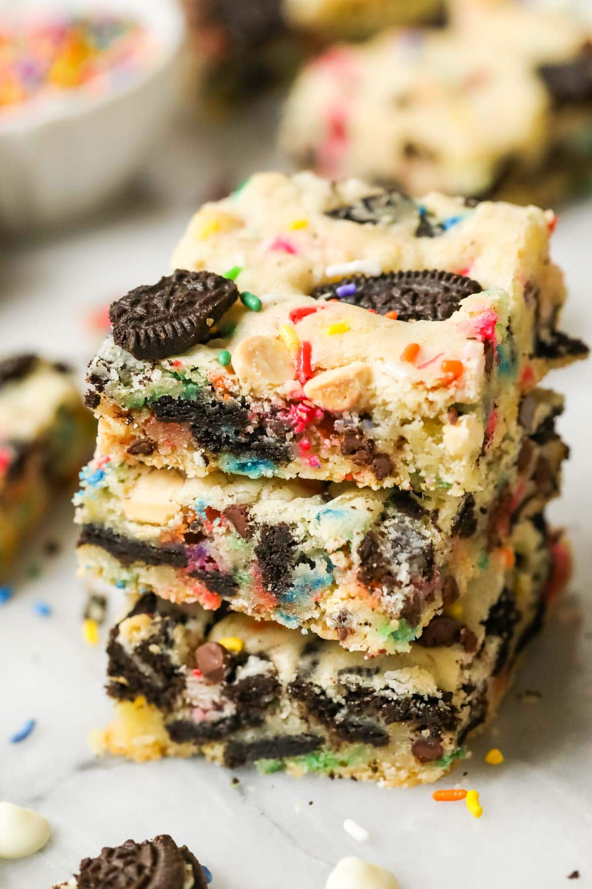 Stack of three funfetti Oreo bars punctuated with bits of Oreo cookies and sprinkles.