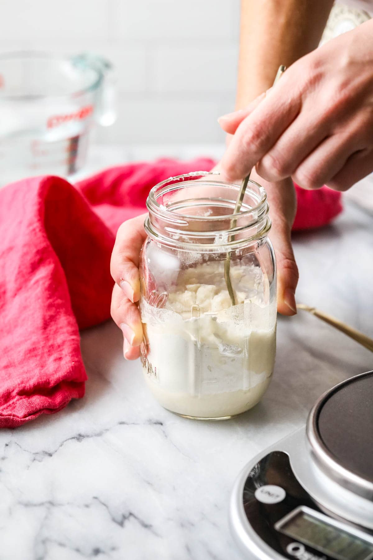 Stirring sourdough starter in mason jar